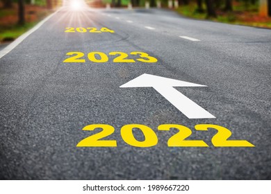 Direction to new year concept and sustainable development idea. Number of 2022 to 2024 on asphalt road surface with marking lines