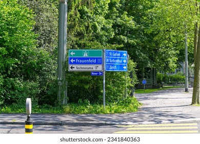 Direction signs at Roman Street with yellow zebra crossing at Swiss City of Winterthur on a sunny spring day. Photo taken June 1st, 2023, Winterthur, Switzerland.