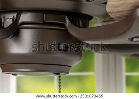 Direction switch on ceiling fan. Indoor heating and cooling savings, energy conservation, and ceiling fan blade rotation concept.