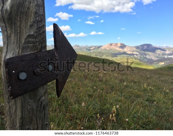Directional arrow on alpine\
trail