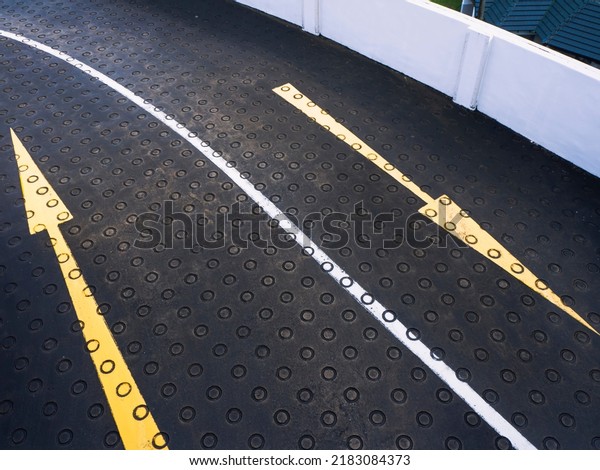 Directional\
arrows on a curved road of an empty car\
park