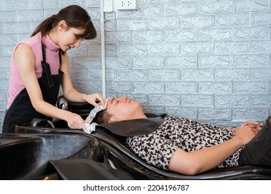 Directly Above Asian Male Lying Down For Hair Wash At Hair Salon With Eyes Closed