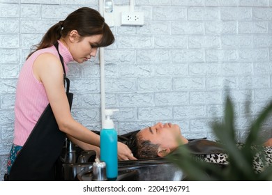 Directly Above Asian Male Lying Down For Hair Wash At Hair Salon With Eyes Closed