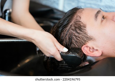 Directly Above Asian Male Lying Down For Hair Wash At Hair Salon With Eyes Closed