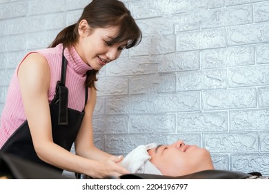 Directly Above Asian Male Lying Down For Hair Wash At Hair Salon With Eyes Closed