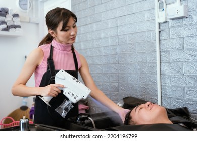 Directly Above Asian Male Lying Down For Hair Wash At Hair Salon With Eyes Closed