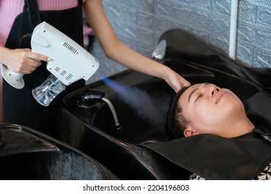 Directly Above Asian Male Lying Down For Hair Wash At Hair Salon With Eyes Closed