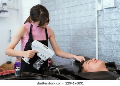 Directly Above Asian Male Lying Down For Hair Wash At Hair Salon With Eyes Closed