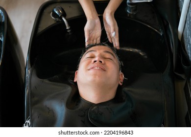 Directly Above Asian Male Lying Down For Hair Wash At Hair Salon With Eyes Closed