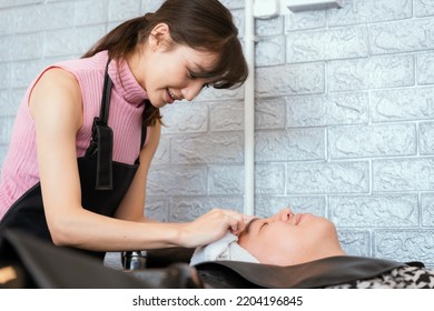 Directly Above Asian Male Lying Down For Hair Wash At Hair Salon With Eyes Closed