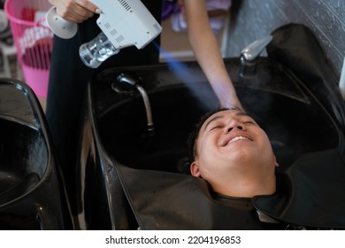 Directly Above Asian Male Lying Down For Hair Wash At Hair Salon With Eyes Closed