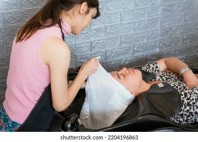 Directly Above Asian Male Lying Down For Hair Wash At Hair Salon With Eyes Closed