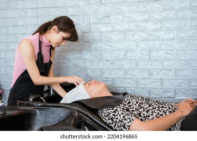 Directly Above Asian Male Lying Down For Hair Wash At Hair Salon With Eyes Closed