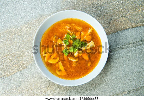 Directly\
above of a plate with Pan Asian traditional seafood soup with\
mussels, calamari, mushrooms served with fresh parsley herbs on\
gray stone table background. Japanese menu\
dish