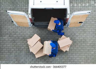 Directly Above Shot Of Delivery Men Unloading Cardboard Boxes From Truck On Street