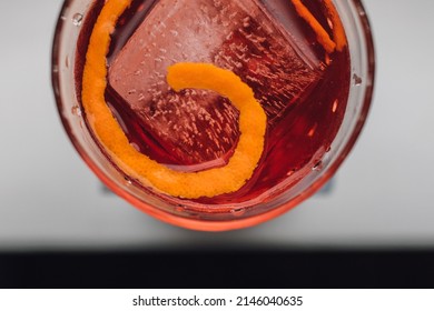 Directly Above Shot Of Electric Red Orange Negroni Cocktail With Orange Twist