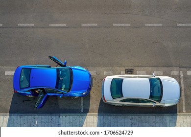 Directly Above View Of Two Parked Passenger Cars, One Of Them With Open Door.