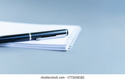 Directly Above View Of White Notepad On Blue Table. Notebook With The Schedule Shoot From The Top. Spiral Notebook Blue Background. Business Concept Planning 2021. View Through Bills And Home Finances