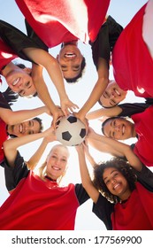 Directly Below Shot Of Female Soccer Team With Ball Forming Huddle Against Clear Sky