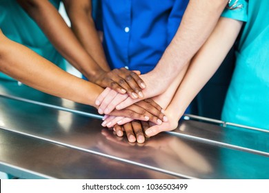 Directly below shot of multiethnic medical team stacking hands over white background