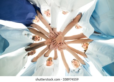 Directly below shot of multiethnic medical team stacking hands over white background