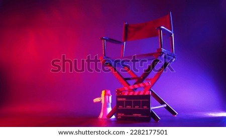 Director chair and clapper board and megaphone in red and blue light color with black background