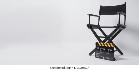 Director chair and Clapper board or movie slate. It's black with yellow color on white background.