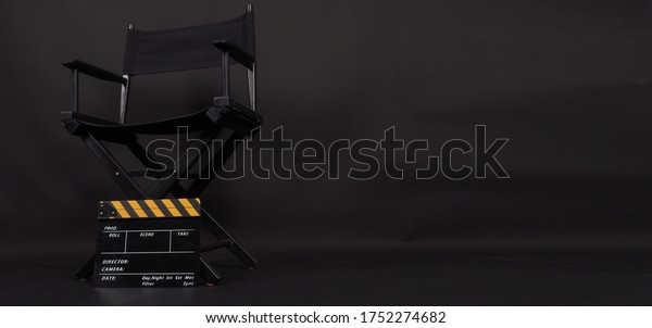 Director chair and Clapper board or movie\
slate use in video production or film and cinema industry. It\'s put\
on black blackground.