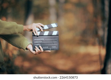 
					Director Holding a Cinema Slate in Outdoors Set. Independent filmmaker using natural light and resources to produce videos
					