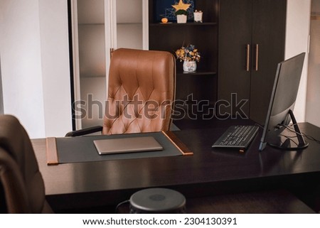 Director's office with large wooden table, leather armchair and PC. Interior design