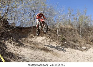 Dirt bike rider jumping off cliff in midair