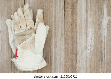 Dirt Covered Leather Work Gloves On Weathered Wood For Your Construction Or Yard Work Message