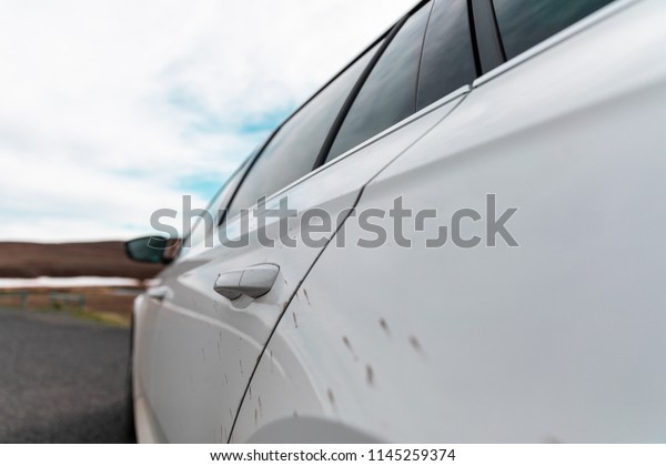 Dirt on white\
station wagon car in\
Iceland