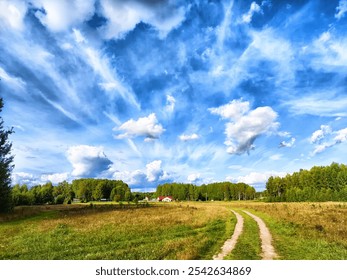 A dirt path meanders through lush green grass and trees, with a vivid blue sky adorned by puffy clouds on a sunny afternoon. - Powered by Shutterstock