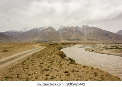 A Dirt Road Along With A Winding River In The Cold Desert Landscape Of The Zanskar Valley In Ladakh.