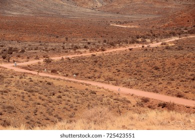 A Dirt Road Cuts Through The Barren, Desolate Landscape Of Namibia.