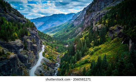 Dirt Road Dangerously On Cliff Edge At The Bottom Of The Mountain Valley