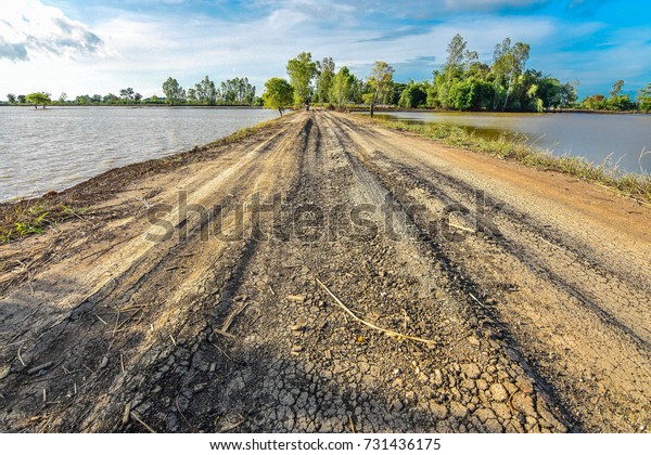 Dirt road with a hole\
along the river.\
