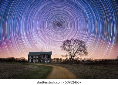 Dirt Road Leading To An Abandoned House And Star Trails 