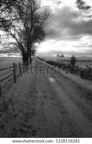 Dirt road leading to horizon at Spangler farm on Gettysburg battlefield in black and white. Spangler farm was used as a hospital during the battle of Gettysburg in 1863.