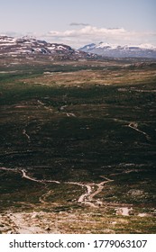 Dirt Road In The Mountains And Snowy Mountains In The Background In Lapland, Finland. Summer Of 2020