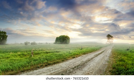 dirt road in a rural field with fog, summer sunset, Russia, Ural