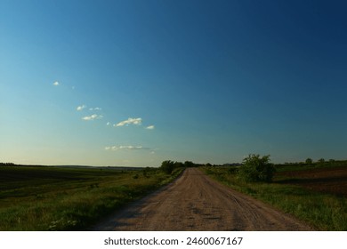 A dirt road through a field