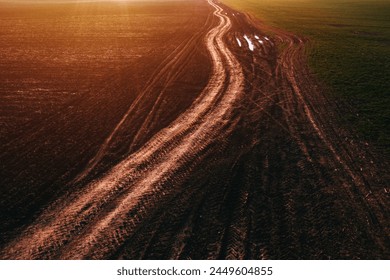 Dirt road with tractor tire track pattern in diminishing perspective, aerial view from drone pov high angle view - Powered by Shutterstock