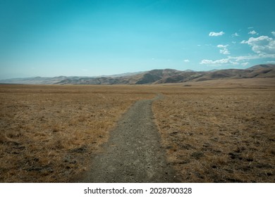  Dirt Road Train Winding Towards Mountains Beneath Blue Sky 