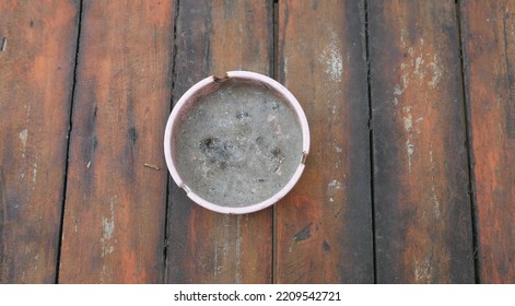 Dirty Ash Tray On Top Of Wooden Table, Taken From Top View