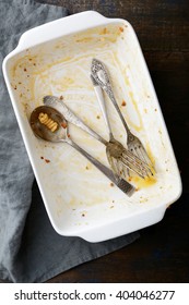 Dirty Baking Dish With Used Fork And Spoon On Wooden Background. Top View