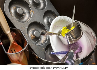 Dirty Baking Dishes In Sink With Donut Pan And Measuring Cup