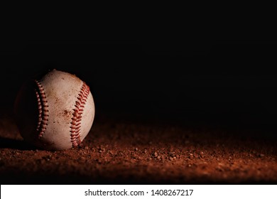 Dirty Baseball Laying In The Dirt At Night