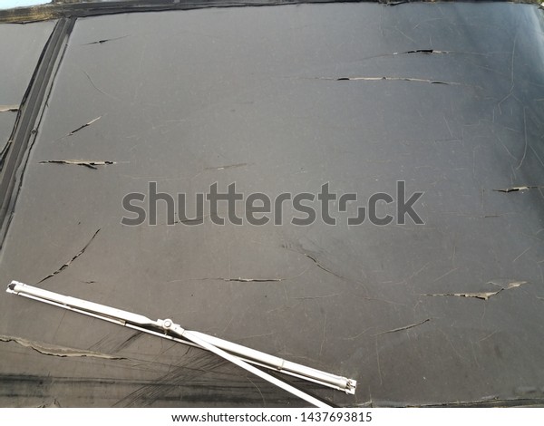 dirty black\
automobile windshield glass with\
wiper